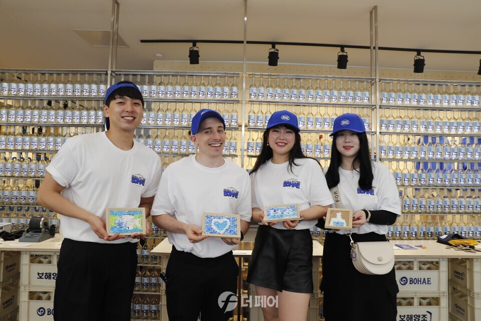 타일러 라쉬가 보해소주 플로깅 센터 & 스몰 액션 스토어를 방문해 업사이클링 굿즈을 살펴보고, 직원들과 기념촬영을 하고 있다. / 사진제공=보해양조