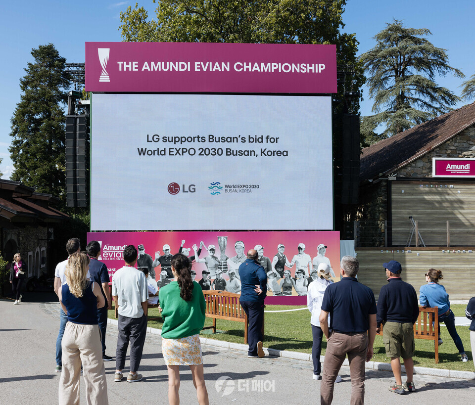 LG전자가 27일부터 4일간 프랑스 에비앙리조트골프클럽에서 열리는 LPGA 투어 아문디에비앙챔피언십을 공식 후원하며 '2030 부산세계박람회' 유치 활동에 나선다. 사진은 관람객들이 경기장 내 대형 전광판에서 상영되는 부산세계박람회 유치 기원 문구를 담은 대회 홍보영상을 보고 있는 모습. / 사진제공=LG전자