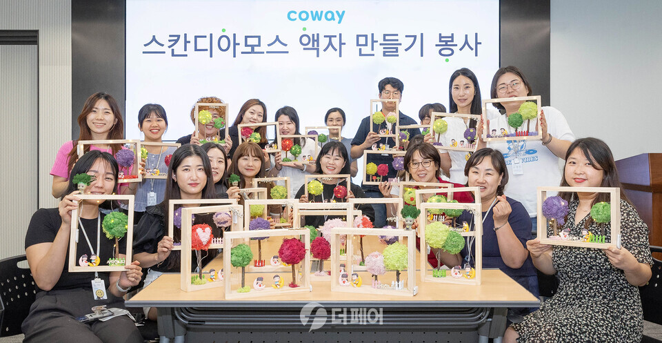 코웨이 임직원들이 스칸디아모스 공기정화액자를 제작해 복지관에 기부했다. / 사진제공=코웨이