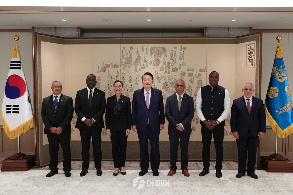 윤석열 대통령이 지난 10일 서울 용산 대통령실 청사에서 한·카리브 고위급 포럼 참석자들과 기념 촬영을 하고 있다.왼쪽부터 올란도 하벳 벨리즈 지속가능개발·기후변화·재난관리부 장관, 에벌리 폴 쳇 그린 앤티가바부다 외교·농업·통상·바부다담당부 장관, 카미나 존슨 스미스 자메이카 외교·통상부 장관, 윤 대통령, 알버트 람찬드 람딘 수리남 외교·국제비즈니스·국제협력부 장관, 앤디 윌리엄즈 그레나다 동원·이행·혁신부 장관, 로돌포 사봉해 카리브 국가연합 사무총장. / 사진제공=대통령실