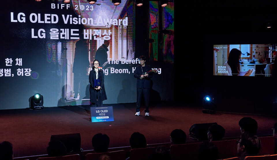 사진제공=LG전자 / 시상식에서 2023년형 LG 올레드 에보(사진 오른쪽)가 수상작 '한 채'를 소개하고 있다. LG 올레드 뉴 비전 상을 수상한 허장(사진 왼쪽), 정범 감독