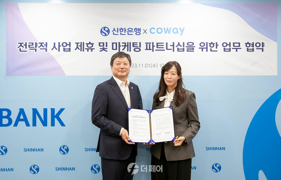 1일 서울 중구 신한은행 본점에서 진행된 협약식에서 심병희 코웨이 마케팅본부장(오른쪽)과 정용욱 신한은행 부행장(왼쪽)이 기념 촬영을 하고 있다. / 사진제공=코웨이