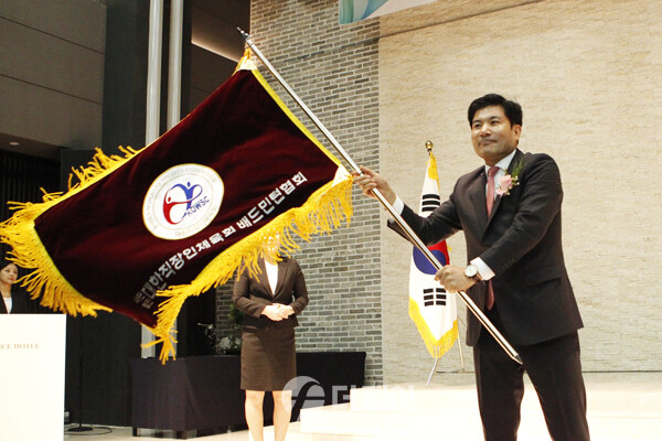 사진 박종천 제3대 대한직장인체육회 전국배드민턴협회장이 취임식에서 협회기를 흔들고 있다.