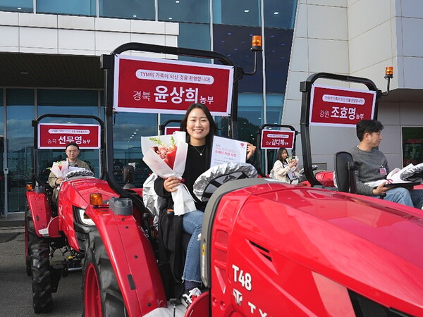 기증받은 TYM 트랙터에 올라 기념사진 촬영을 하고 있는 청년 농부들