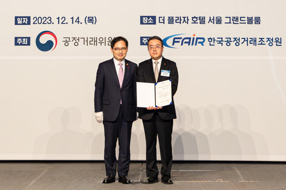 사진제공=롯데건설 / 롯데건설 준법경영부문 조도휘 상무(사진 오른쪽)가 한기정 공정거래위원장(사진 왼쪽)으로부터 우수기업 평가증을 수여한 후 기념 촬영을 하고 있다.