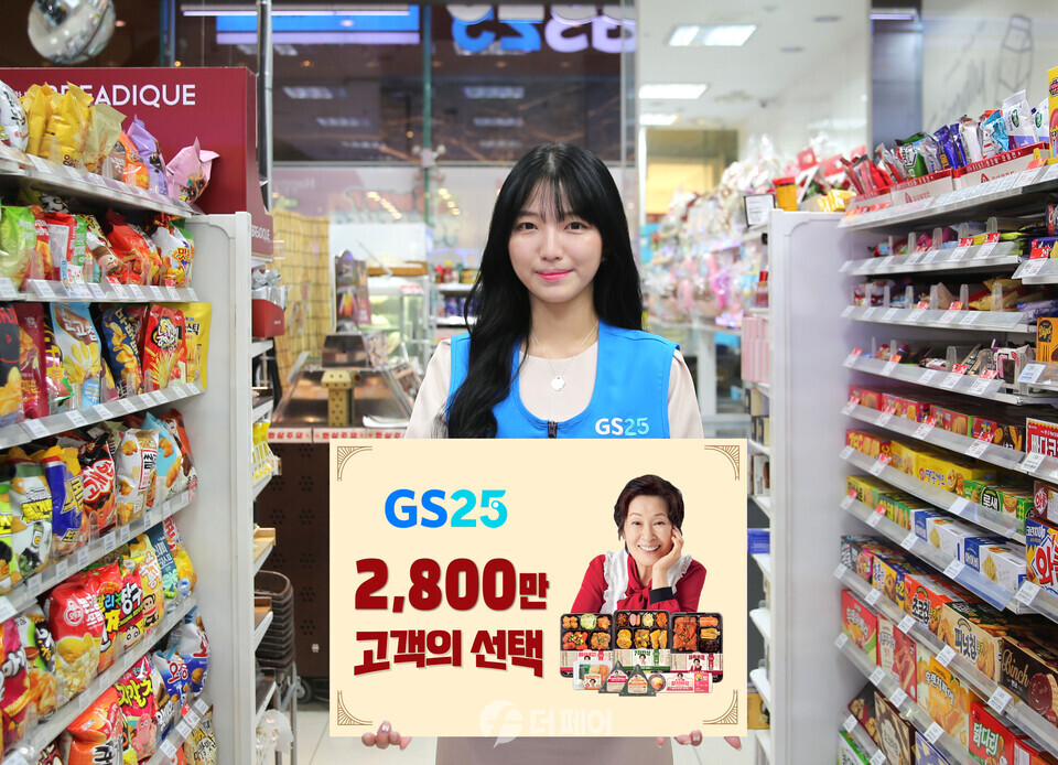 GS25에서 모델이 혜자브랜드 상품 2,800만개 판매 돌파 기념 판넬을 들고 있다. / 사진제공=GS25