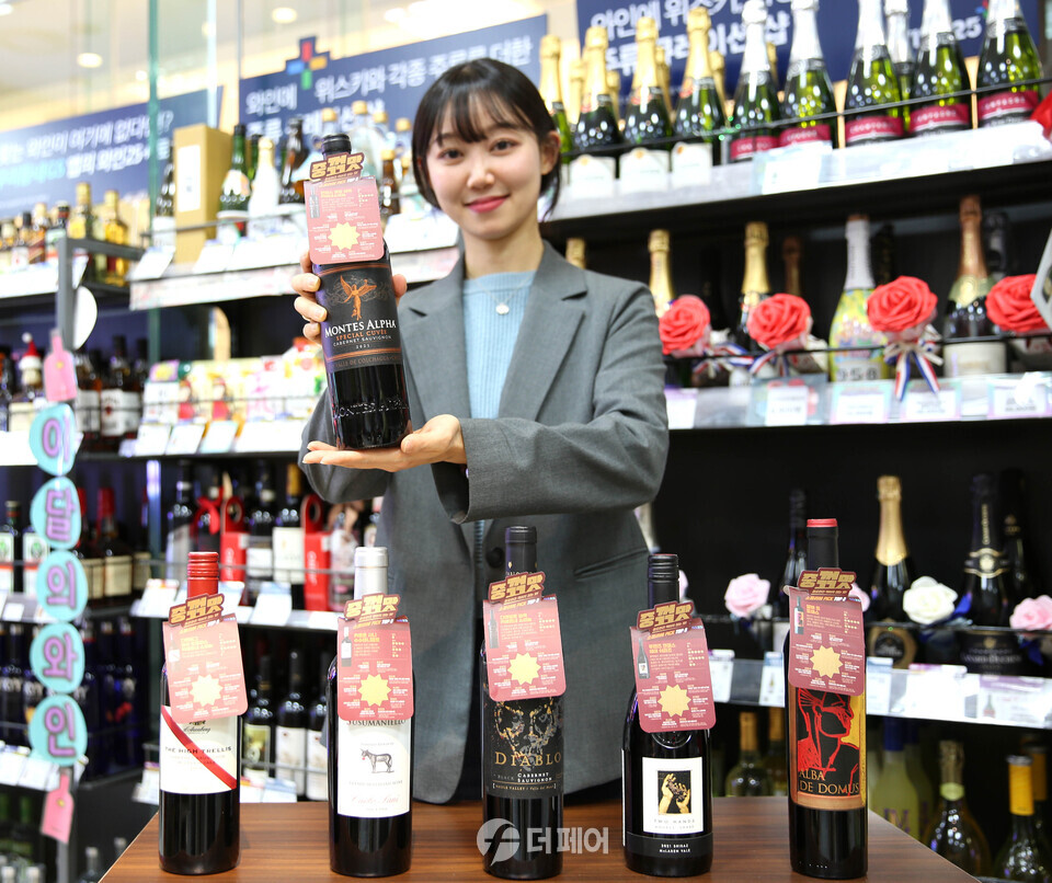 GS25에서 모델이 이달의 와인으로 선정된 와인을 들고 포즈를 취하고 있다. / 사진제공=GS25