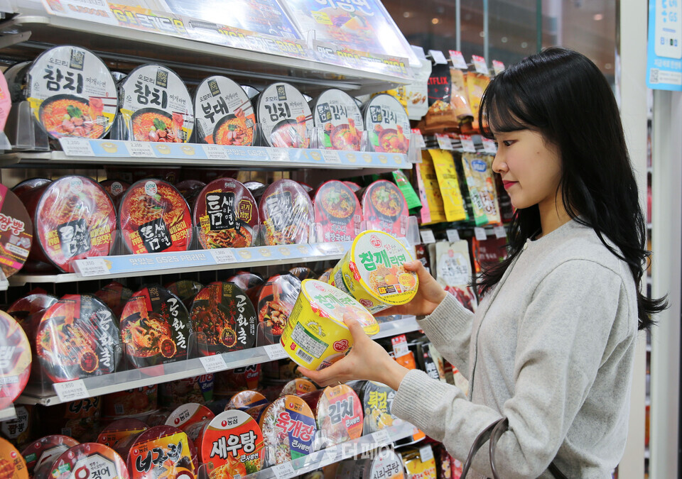 모델이 갓세일 행사상품 참깨라면 1+1을 고르고 있다. / 사진제공=GS25