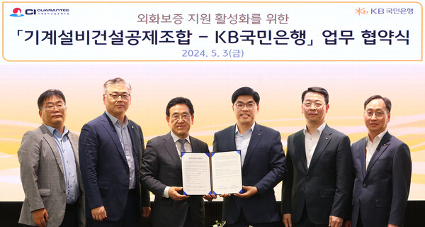 사진제공=KB국민은행 / 지난 3일 서울시 영등포구 여의도 소재 KB국민은행 신관에서 열린 '외화보증 지원 활성화를 위한 기계설비건설공제조합-KB국민은행 업무 협약식'에서 김종서 기계설비건설공제조합 이사장 직무대행(좌측에서 3번째)과 이상신 KB국민은행 외환사업본부장(우측에서 3번째) 및 양사 관계자들이 기념사진을 촬영하고 있다.