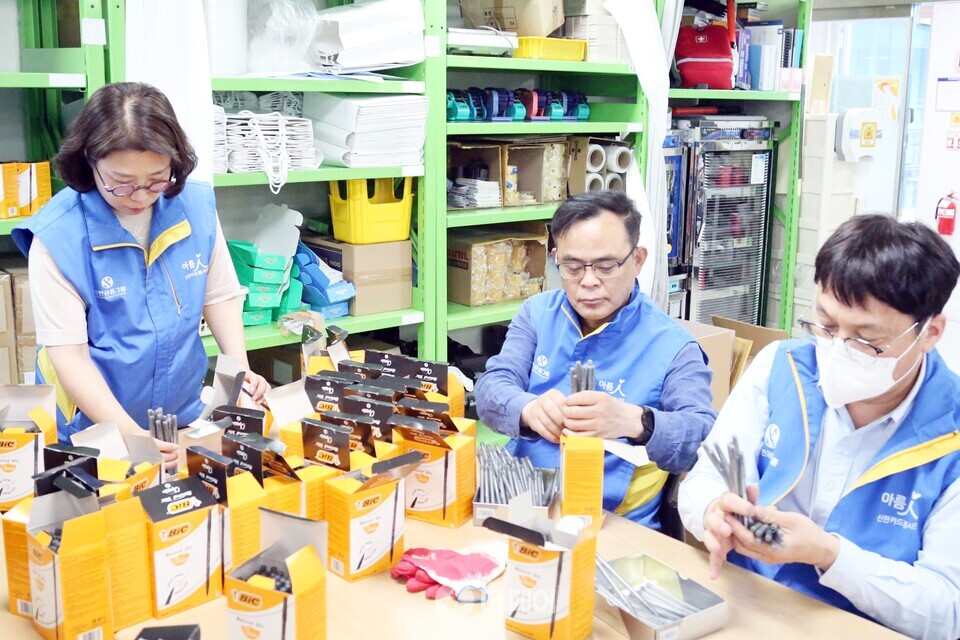 신한카드 임원들이 장애인 보호작업장 물품포장 보조 활동을 하고 있다. / 사진제공=신한카드