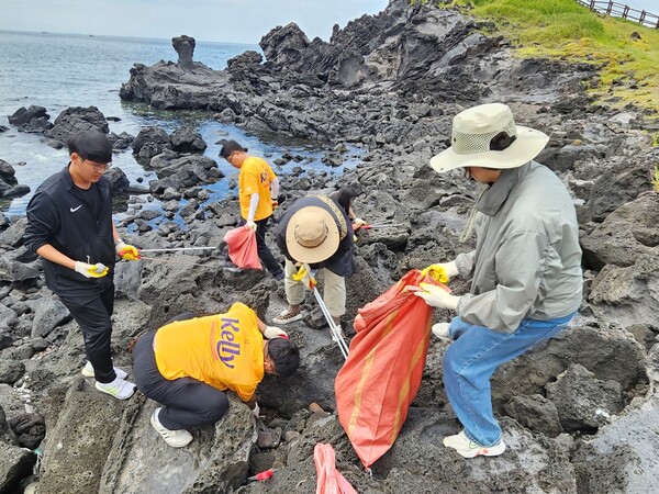 사진제공=하이트진로 / 지난 30일 제주 닭머르해안에서 하이트진로 제주지점 임직원들과 제주대학교 학생 및 교직원들이 환경정화 활동을 진행했다.