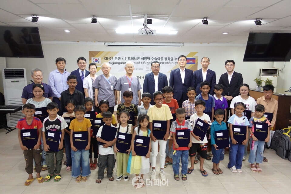 12일 캄보디아 프놈펜 소재 헤브론의료원에서 열린 'KB국민은행 X 위드헤브론 심장병 수술아동 장학금 수여식'에서 배기안 헤브론병원장(좌측 네 번째), 김우정 헤브론의료원장(좌측 다섯 번째), 옴 쌈은 KB프라삭은행장(우측 네 번째), 김현종 KB프라삭은행 부행장(우측 세 번째) 등이 기념사진을 촬영하고 있다. / 사진제공=KB국민은행