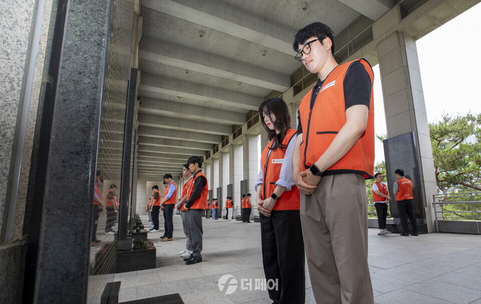 호반사랑나눔이 전쟁기념과 봉사활동: 호반 신입사원들이 묘비에 헌화 및 묵념을 하고 있다. / 사진제공=호반그룹
