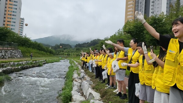 충주시자원봉사센터가 운영하는 12기 둥글레가족봉사단이 호암천(호암물정원)일원에서 직접만든 EM흙공을 던지고 주변 환경정화를 진행했다. 사진=충주시