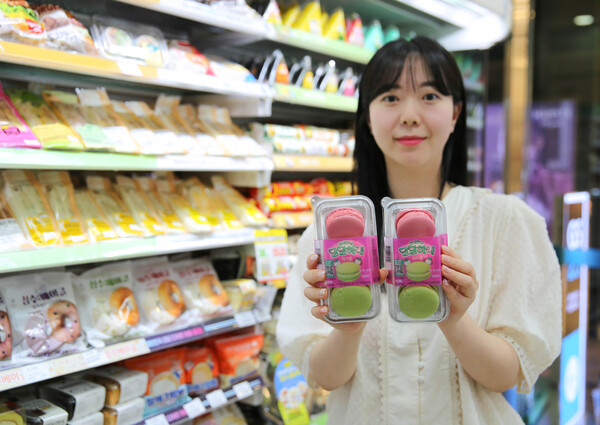 모델이 GS25와 하나은행이 협업해 선보인 달달하나 마카롱 상품을 들고 포즈를 취하고 있다. / 사진=GS25