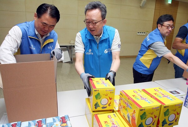 지난 7월 31일 서울시 중구 소재 본점에서 취약계층 아동 여가지원 KIT 제작 봉사활동을 진행하고 신한은행 정상혁 은행장(가운데), 신한저축은행 이희수 사장(왼쪽), 신한리츠운용 김지욱 대표이사(왼쪽 다섯번째)가 학습놀이 키트를 제작하고 있는 모습 / 사진=신한은행