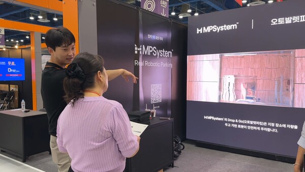 삼표그룹의 로봇주차 시스템인 ‘엠피시스템’ (MPSystem)을 설명하고 있는 직원과 주의깊게 경청하고 있는 참관객의 모습. / 사진 =삼표그룹