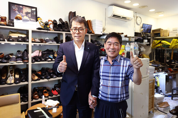 서울 염천교 수제화거리를 방문한 김성태 IBK기업은행장(왼쪽)이 수제화를 구입하고 고기황 이태리제화 대표(오른쪽)와 기념촬영을 하고 있다. 사진=IBK기업은행