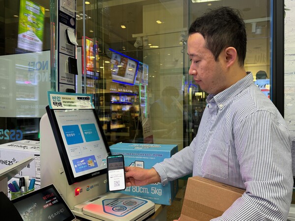 GS25에서 고객이 QR 간편 예약접수 기능을 이용해 택배 접수를 진행하고 있다. 사진= GS25