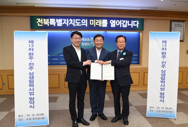 완주‧전주 상생협력사업 협약식에 참석한 김관영 도지사(가운데), 유희태 완주군수(오른쪽), 우범기 전주시장(왼쪽)이 협약서를  함께 펴들고 기념 촬영을 하고 있다. / 사진 = 완주군