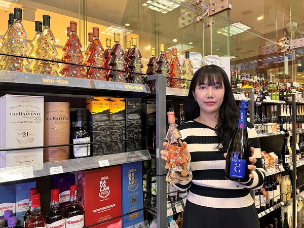 GS25에서 고객이 연말 와인 상품을 들고 포즈를 취하고 있다. 사진= GS리테일