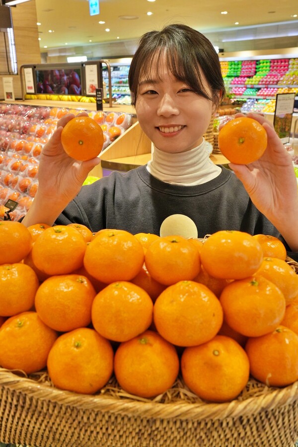 본점 지하 1층 식품관에서 감귤을 들고 있는 모델. 사진= 롯데백화점