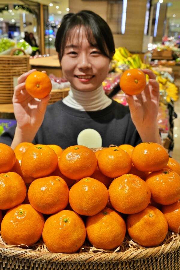 본점 지하 1층 식품관에서 감귤을 들고 있는 모델. 사진= 롯데백화점