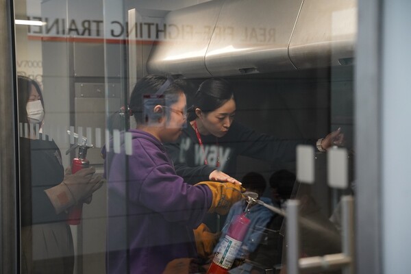 지난 14일 티웨이항공 훈련센터에서 객실 승무원 체험 활동에 참여한 천안 목천 꿈샘지역아동센터 청소년들이 기내 화재 진압 실습 훈련을 하고 있다. / 사진=티웨이항공