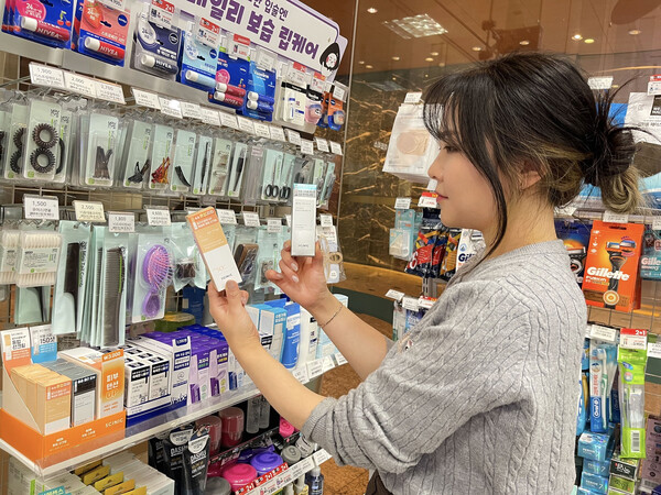 모델이 GS25에서 출시한 3000원 가성비 화장품을 살펴보고 있다. / 사진=GS리테일