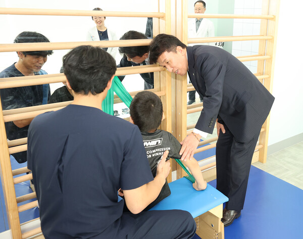 함영주 회장(사진 맨 오른쪽)이 17일 중추신경계 발달치료를 받고 있는 장애 아동에게 격려의 말을 전하고 있다. 사진=하나금융그룹