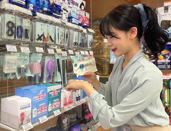 GS25에서 모델이 파우치 타입의 화장품을 사용해 보고 있다 / 사진=GS리테일