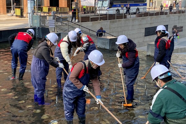 서울 중구에 위치한 청계천의 바닥 퇴적물을 제거하고 있는 롯데마트와 슈퍼 임직원 모습 / 사진=롯데쇼핑