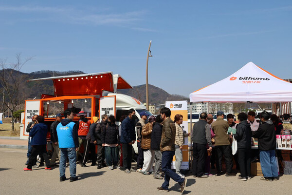 3월 29일 빗썸나눔 임직원들이 영덕국민체육센터 앞에서 주민들에게 음식과 생필품 등 구호물품을 나누고 있다 / 사진=빗썸