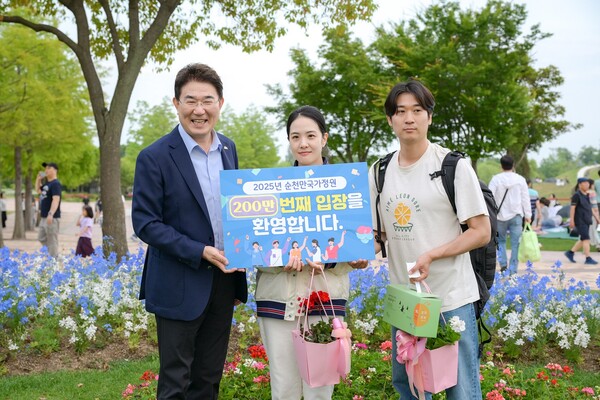 노관규 순천시장이 서울에서 방문한 200만 번째 관람객 부부와 함께 기념 사진을 촬영하고 있다 / 사진=순천시