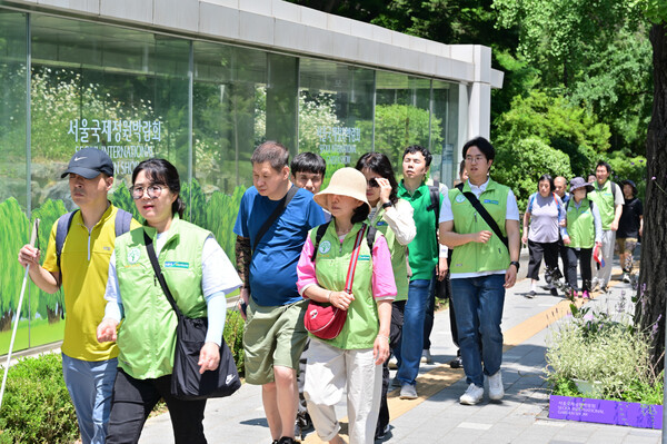 6월 12일 농협유통 임직원들이 새빛맹인선교회 시각장애인들의 산책 도우미 활동을 위해 보라매공원을 찾았다./ 사진=농협유통