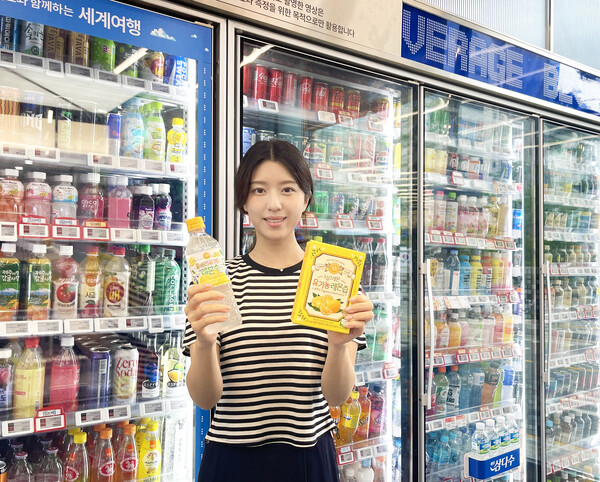GS25에서 모델이 홀베리유기농레몬수500ML(왼쪽)과 GS샵에서 판매하고 있는 홀베리 유기농 레몬즙 상품을 들고 있다. / 사진=GS리테일