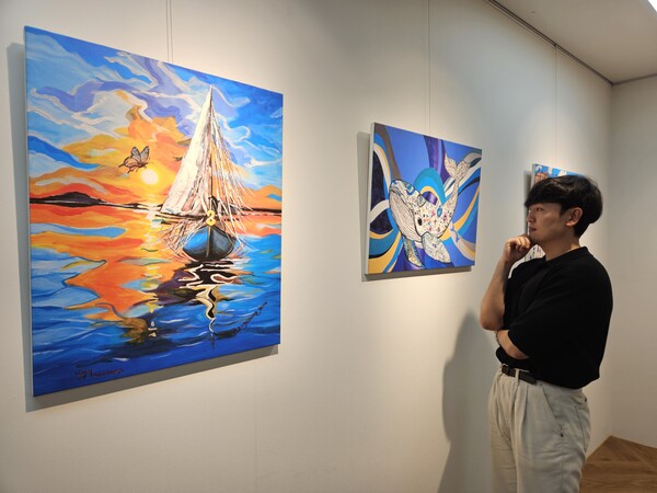 현대제철 직원이 ㈜올모용인 사업장에 걸린 소속 발달장애인 작가들의 작품을 감상하고 있다 / 사진=현대제철