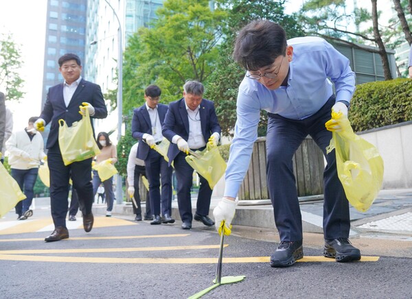 지난 29일 여의도 한강공원 일대에서 진행된 임직원 플로깅 데이에 참여한 KB금융지주 임직원이 환경 정화 활동을 하고 있다. 사진 = KB금융지주