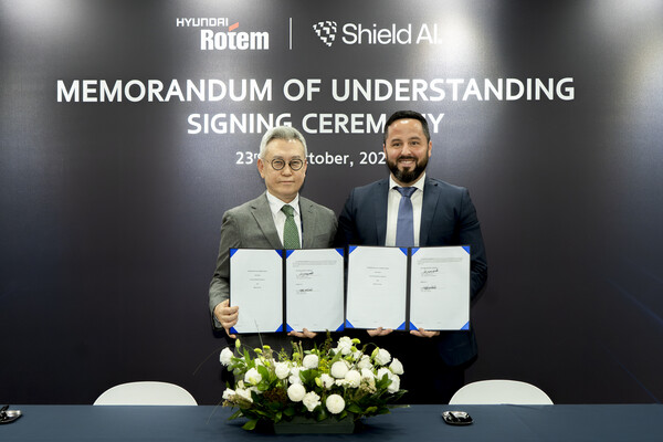 이정엽(왼쪽) 현대로템 부사장과 마이크 한린 쉴드AI 글로벌 전략 및 사업개발 총괄이 지난 23일 경기 고양시 킨텍스(KINTEX)에서 열린 ‘2025 서울 국제 항공우주 및 방위산업 전시회(ADEX)’에서 ‘국방 AI 기반 다목적 드론 운용 기술 개발을 위한 업무협약’을 체결한 후 기념촬영을 하고 있다. / 사진=현대로템