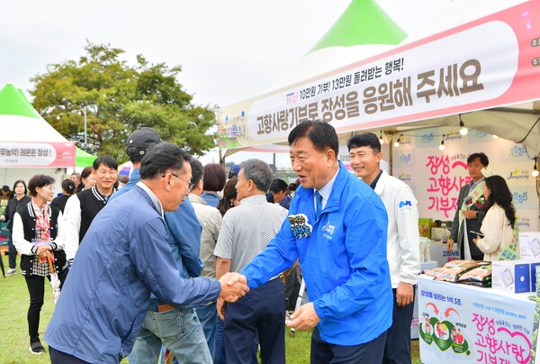 지난 황룡강 가을꽃축제 기간 고향사랑기부제 홍보부스를 찾은 김한종 장성군수가 방문객을 반기고 있다. / 사진=장성군
